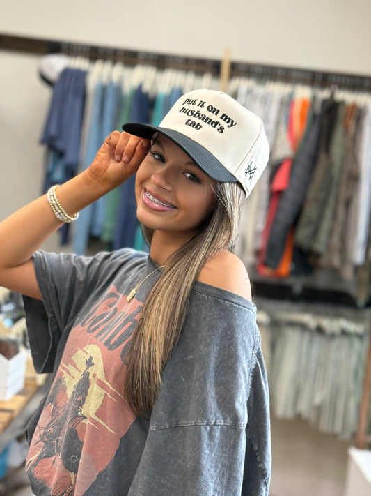 MHC Put it on my Husband's Tab Trucker Hat: Black/Natural Otto